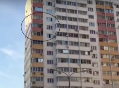 В Краснодаре мужчина повис на балконе между 11 и 12 этажом — очевидцы сняли видео