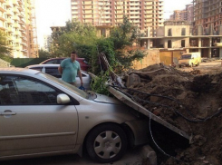 В Краснодаре экскаватор опрокинул бетонный забор на припаркованные легковушки