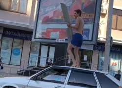  Неадекватный мужчина с крылом залез на крышу авто в Новороссийске 