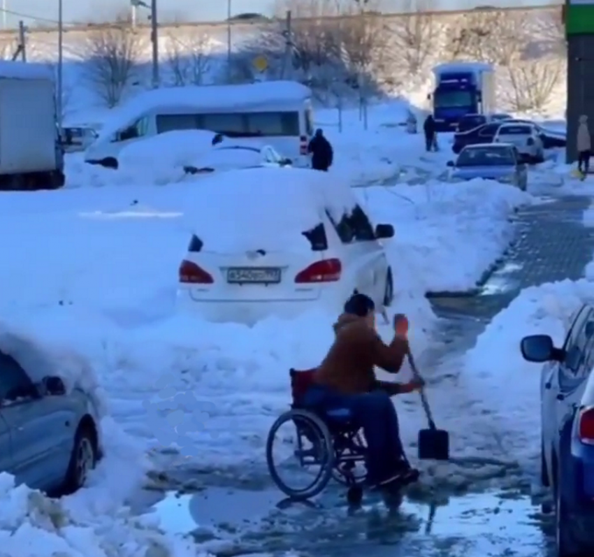 В Краснодаре сняли на видео колясочника, чистящего дорожки от снега